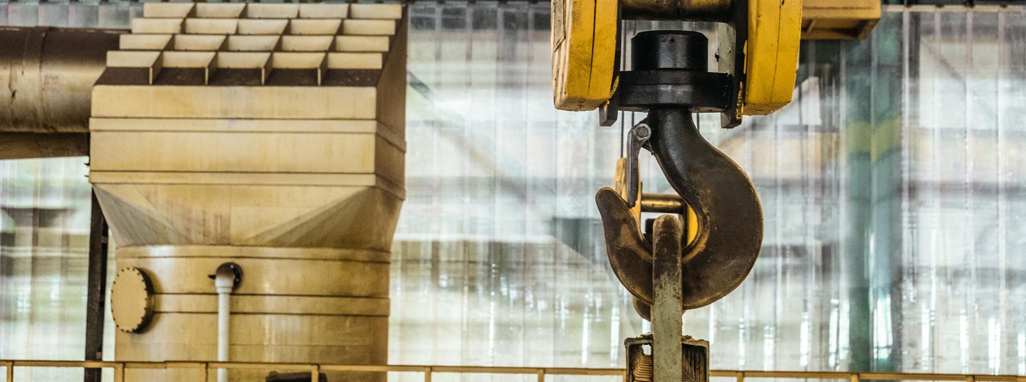 Steel hook of overhead crane over industrial equipment